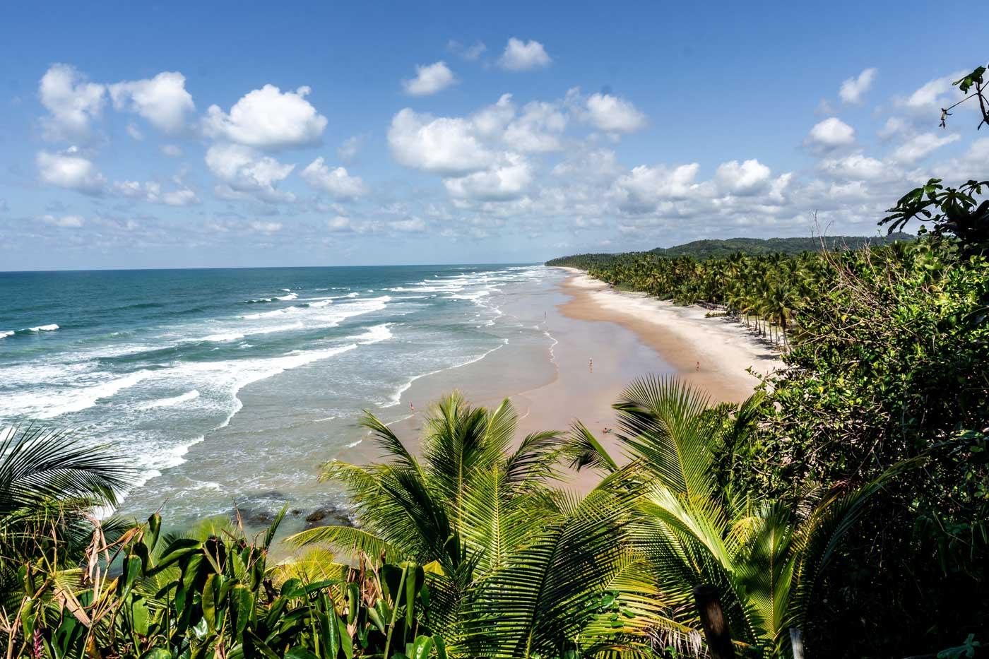 Vista a&eacute;rea de Itacar&eacute;, Bahia, com praias cercadas pela Mata Atl&acirc;ntica e mar cristalino no litoral brasileiro.
