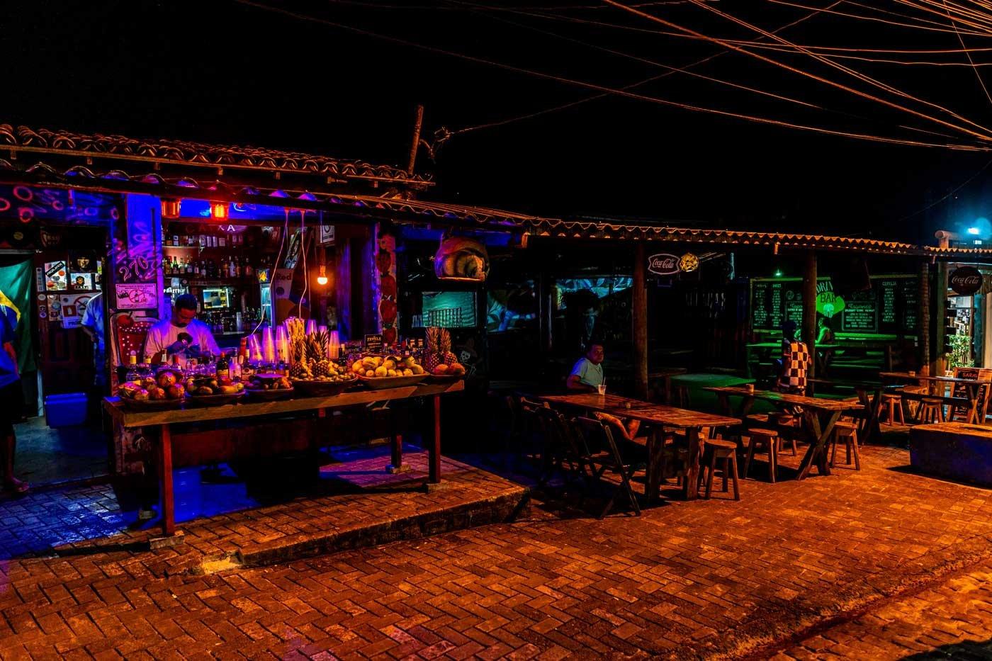 Noite em Itacar&eacute;, Bahia, com bares iluminados, m&uacute;sica e um ambiente jovem e acolhedor.